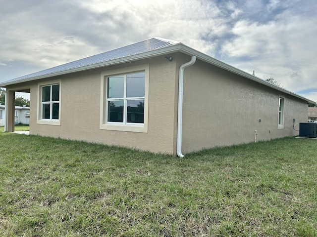 view of home's exterior featuring central air condition unit and a yard