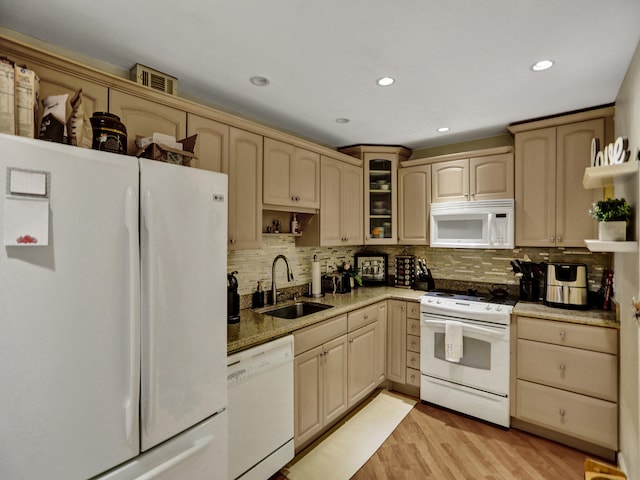 kitchen with decorative backsplash, light brown cabinetry, white appliances, sink, and light hardwood / wood-style floors