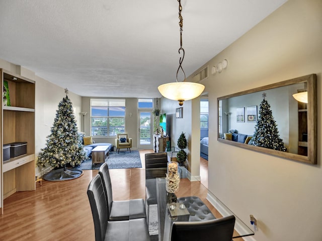 dining room with hardwood / wood-style floors and a textured ceiling