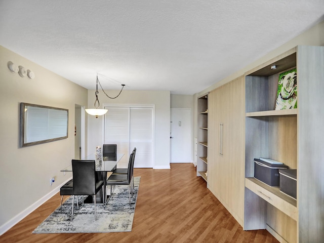 dining room featuring a textured ceiling and dark hardwood / wood-style flooring