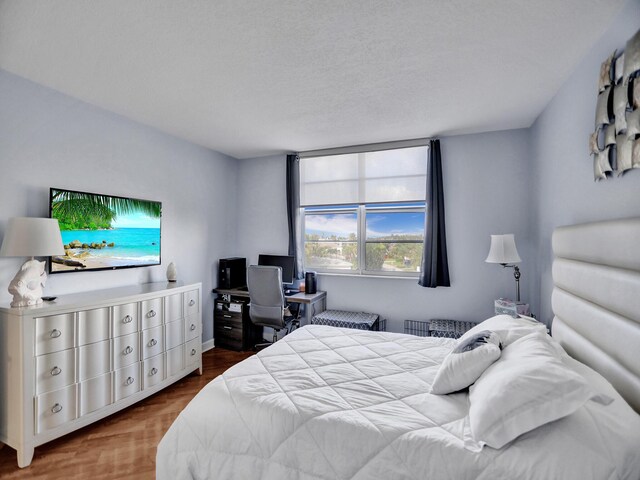 bedroom with hardwood / wood-style flooring and a textured ceiling