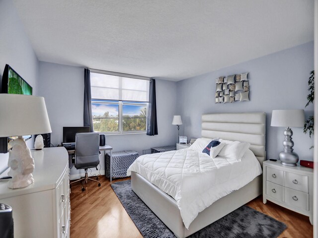 bedroom featuring hardwood / wood-style floors and a textured ceiling