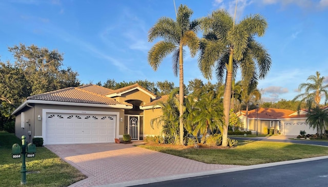 mediterranean / spanish-style house featuring a front yard and a garage