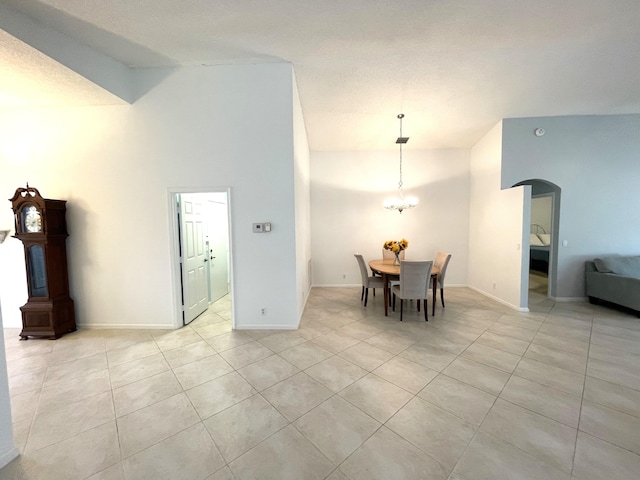 dining area with light tile patterned flooring, a chandelier, and high vaulted ceiling