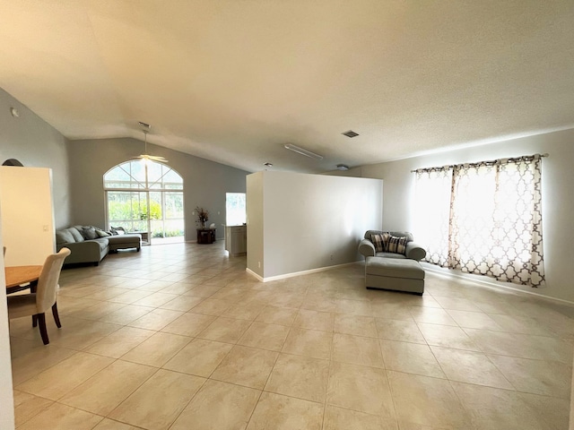 living area with light tile patterned flooring and vaulted ceiling