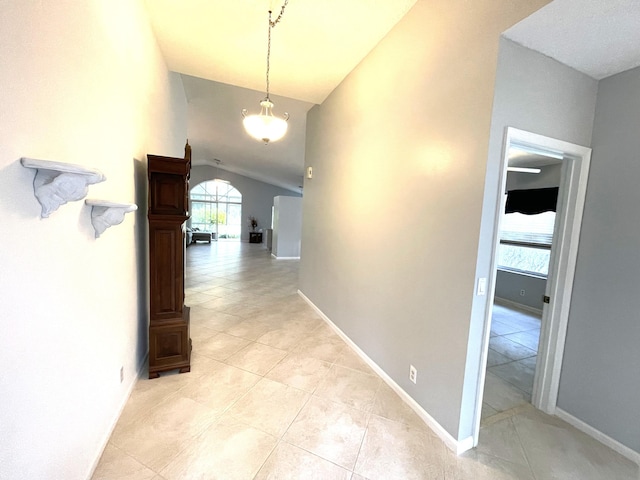 hall featuring lofted ceiling and light tile patterned floors