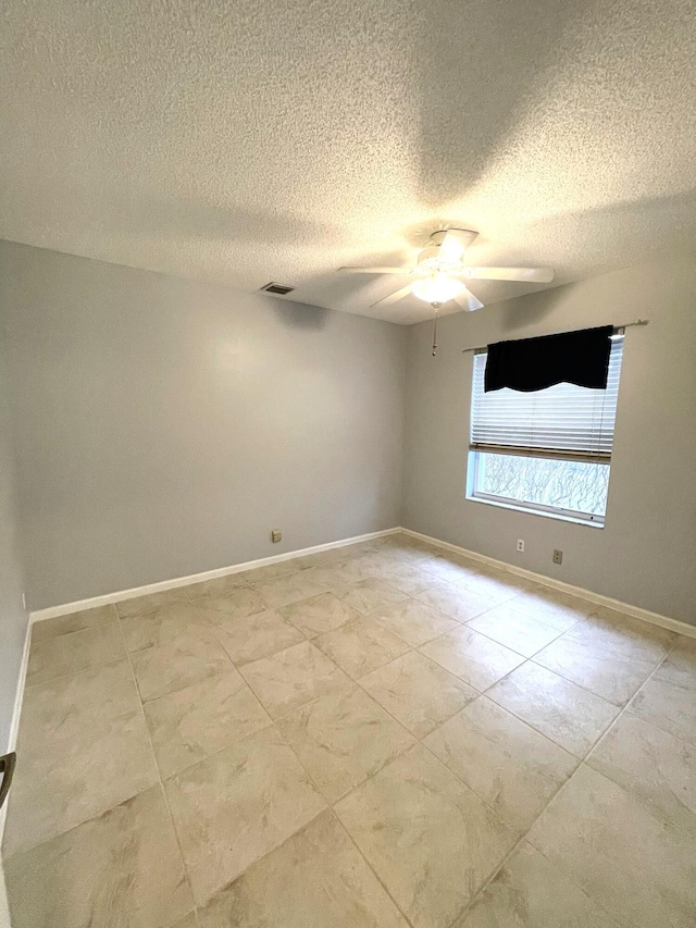 empty room featuring a textured ceiling and ceiling fan