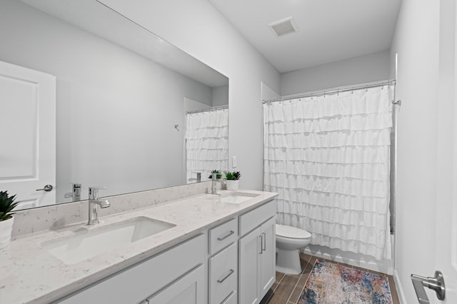 full bathroom with hardwood / wood-style floors, vanity, toilet, and shower / bath combination with curtain