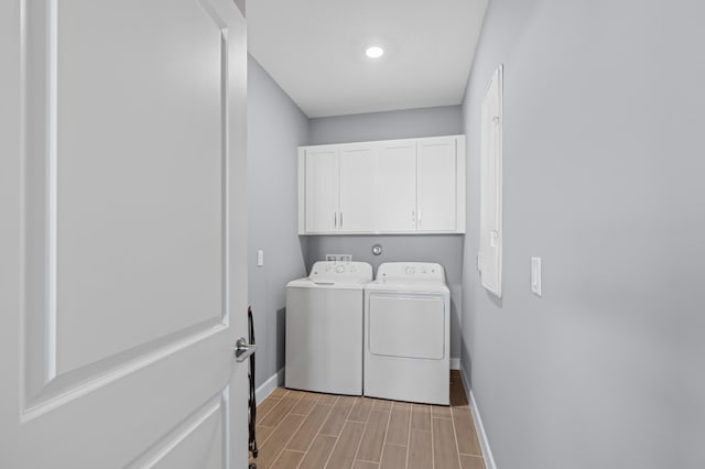 laundry area with cabinets, separate washer and dryer, and light hardwood / wood-style flooring