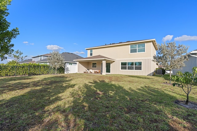 rear view of house featuring a yard