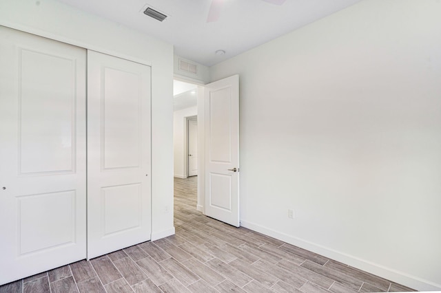 unfurnished bedroom with ceiling fan and a closet