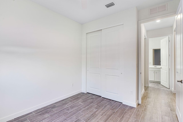 unfurnished bedroom featuring ceiling fan and a closet