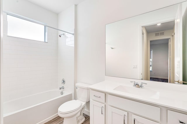 full bathroom with hardwood / wood-style floors, vanity, shower / bath combination, and toilet