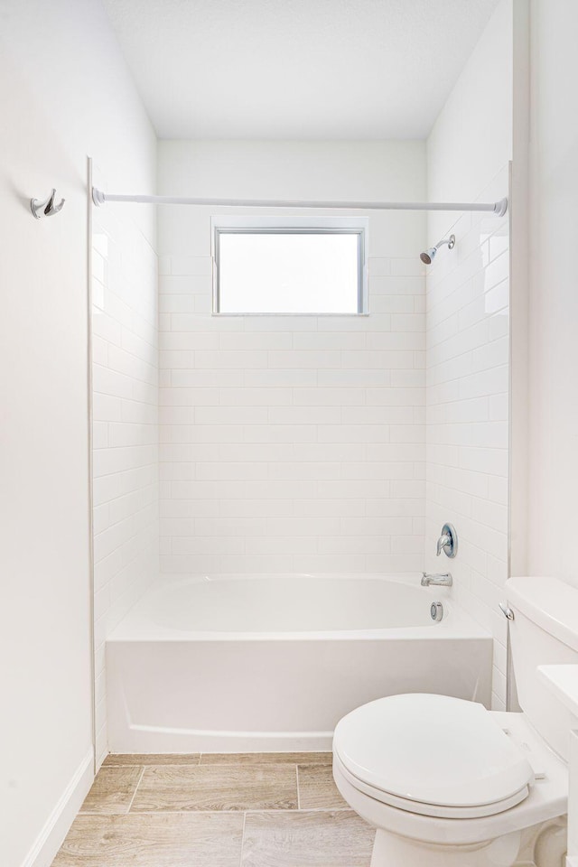 bathroom featuring tiled shower / bath combo and toilet