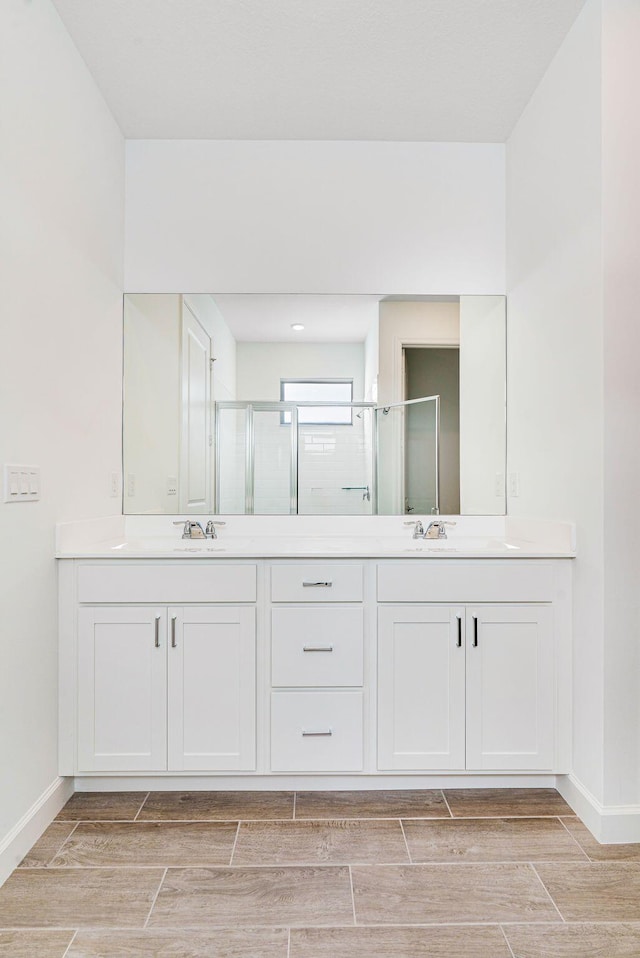 bathroom featuring vanity and a shower with door