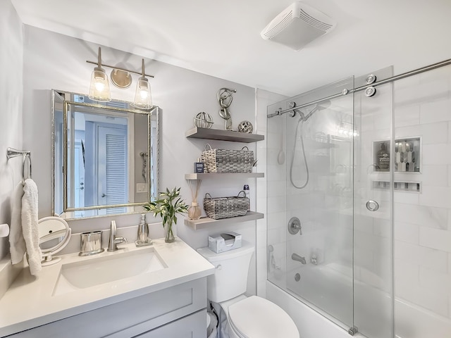 full bathroom with combined bath / shower with glass door, vanity, and toilet