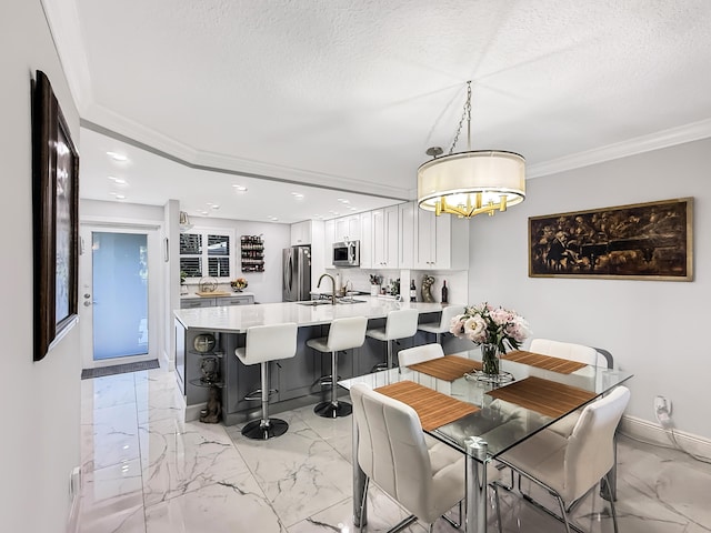 dining room with crown molding, sink, and a textured ceiling