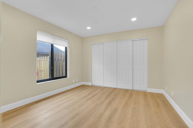 unfurnished bedroom with a closet and light hardwood / wood-style floors