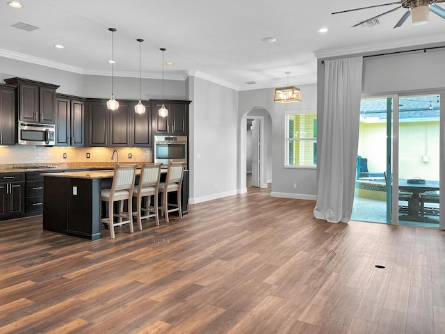 living room with ceiling fan with notable chandelier, crown molding, and dark wood-type flooring