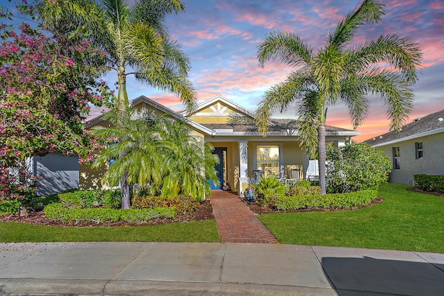 view of front facade with a porch and a lawn