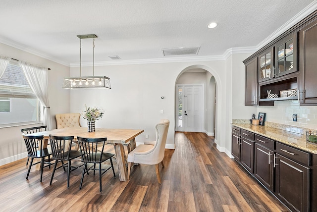 dining room featuring dark wood-type flooring and ornamental molding