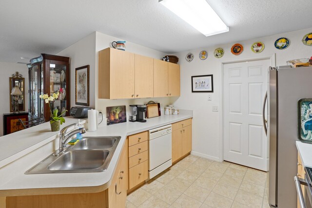 kitchen featuring kitchen peninsula, light brown cabinetry, stainless steel fridge, dishwasher, and sink