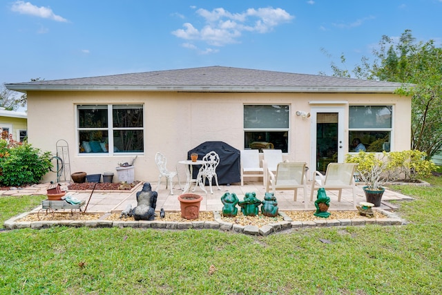 back of property with a lawn and a patio