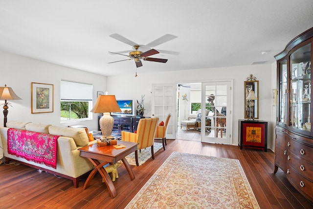 living room with dark wood-type flooring, ceiling fan, and french doors