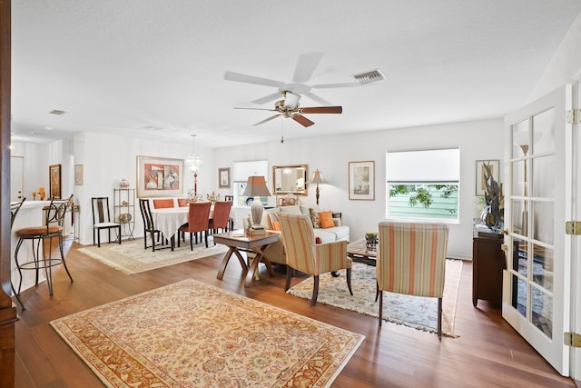 living room with wood-type flooring, a textured ceiling, and ceiling fan