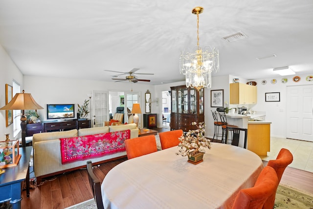 dining room featuring light hardwood / wood-style floors and ceiling fan with notable chandelier