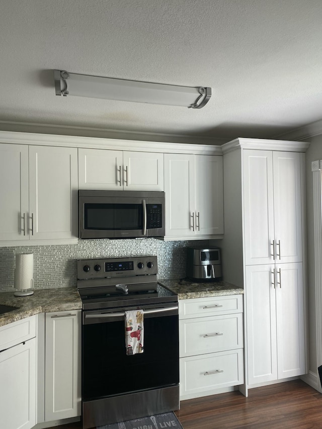 kitchen featuring white cabinetry, dark wood-type flooring, a textured ceiling, and appliances with stainless steel finishes