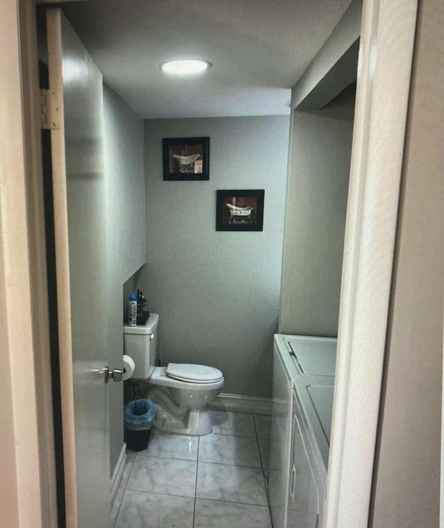 bathroom featuring independent washer and dryer and toilet