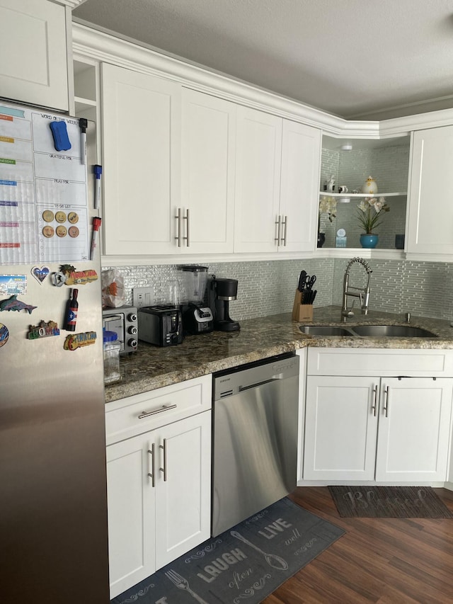 kitchen featuring stainless steel appliances, white cabinetry, dark hardwood / wood-style floors, and sink