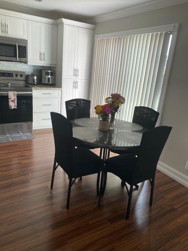 dining room with crown molding and dark hardwood / wood-style floors