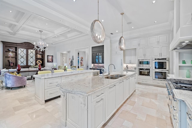 kitchen featuring sink, pendant lighting, a center island with sink, and coffered ceiling