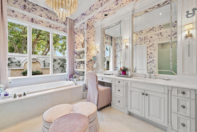 bathroom featuring vanity, an inviting chandelier, and a relaxing tiled tub