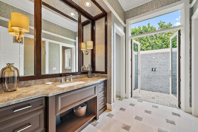 bathroom featuring crown molding, tiled shower, and vanity