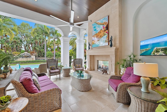 view of patio / terrace with ceiling fan, a swimming pool, and an outdoor living space with a fireplace