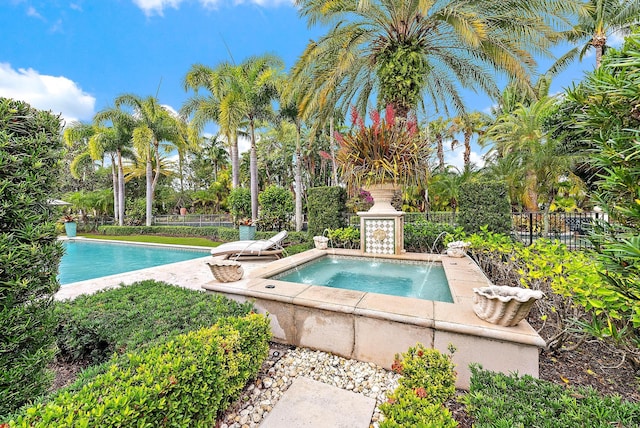 view of swimming pool featuring an in ground hot tub