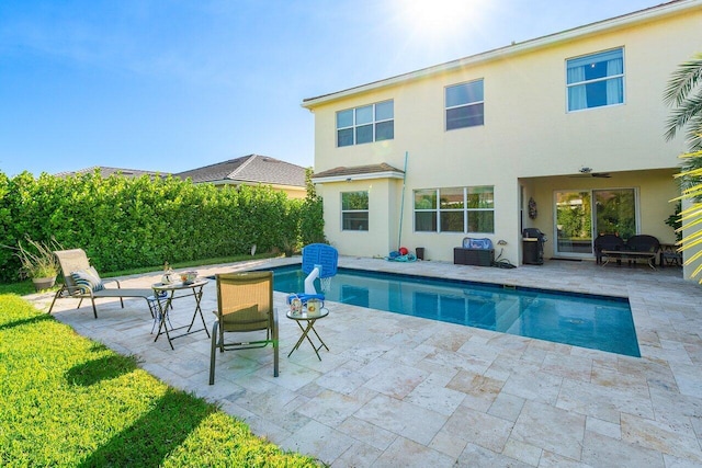 view of swimming pool with ceiling fan, area for grilling, and a patio area