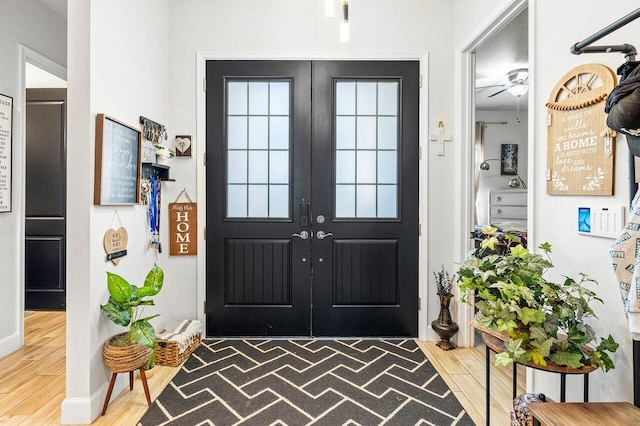 entrance foyer with ceiling fan, french doors, and wood-type flooring