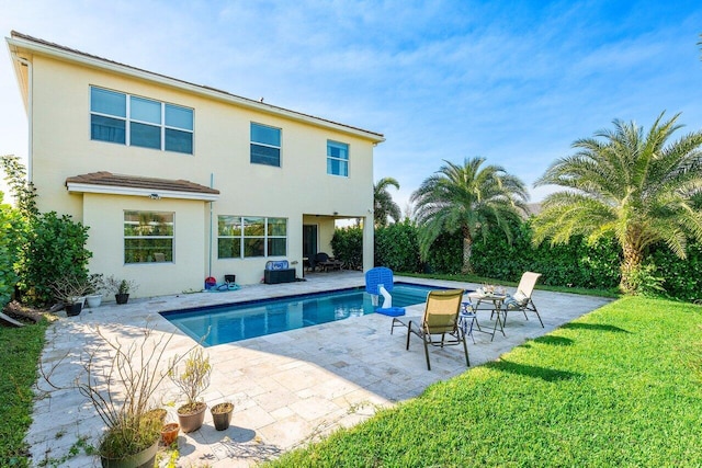 view of swimming pool featuring a lawn and a patio