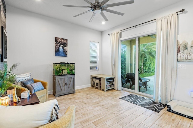 living room with light hardwood / wood-style flooring, ceiling fan, and a healthy amount of sunlight