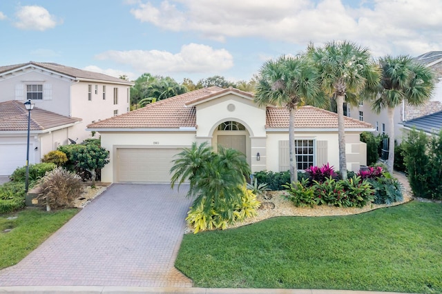 mediterranean / spanish house with a garage and a front lawn