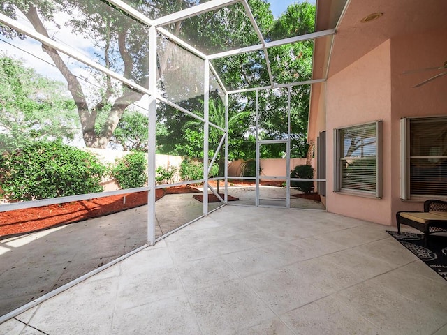 view of patio with glass enclosure and ceiling fan