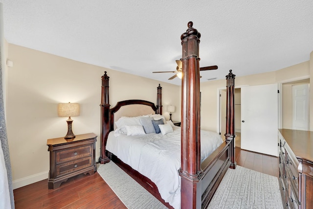 bedroom with a textured ceiling, dark hardwood / wood-style flooring, and ceiling fan