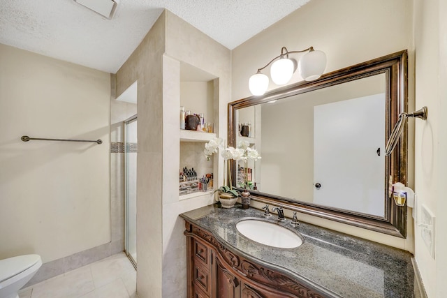 bathroom featuring tile patterned flooring, vanity, a textured ceiling, and walk in shower