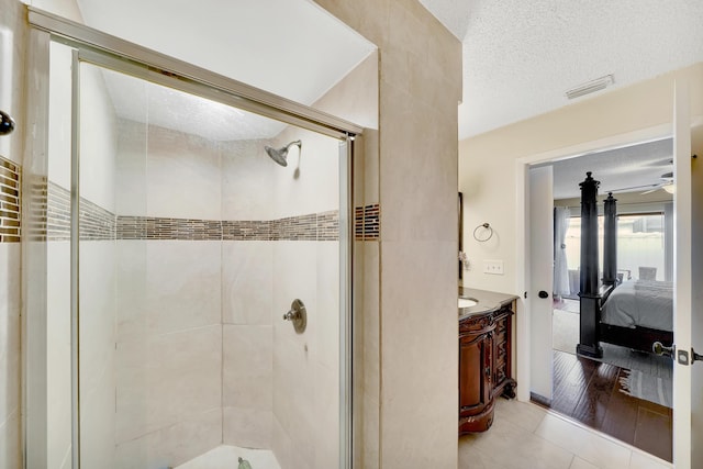 bathroom with vanity, a textured ceiling, a shower with door, ceiling fan, and hardwood / wood-style floors