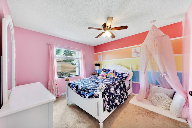 bedroom with ceiling fan, light carpet, and a textured ceiling