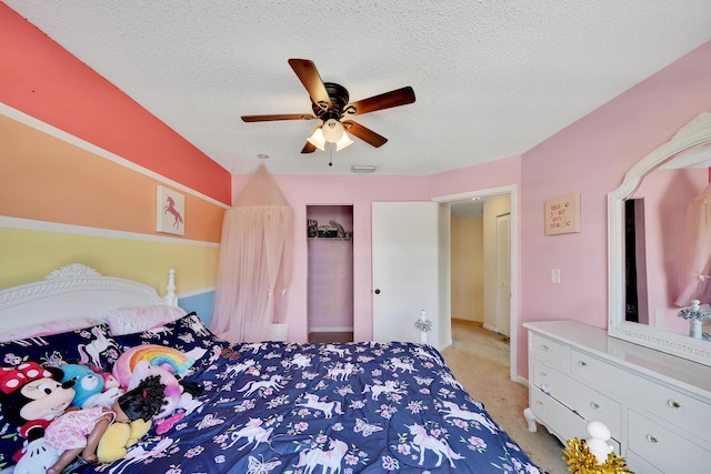 carpeted bedroom with ceiling fan and a textured ceiling